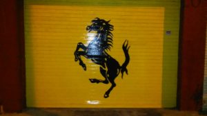 Metal garage door pained yellow and black like the Ferrari logo Cavallino Rampante