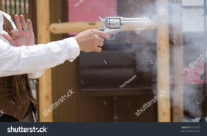 picture of a single action six shooter firing with smoke